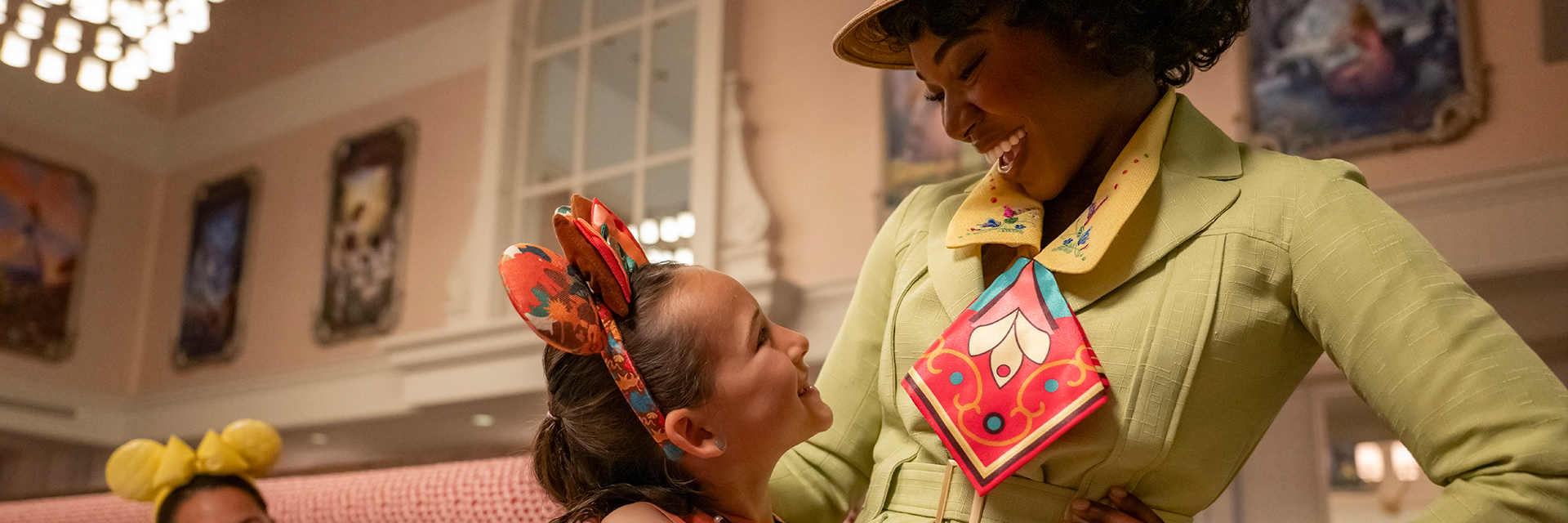 Princess Tiana standing and laughing with little girl at 1900 Park Fare dining.