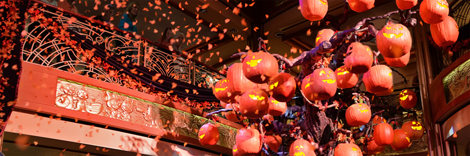 Photo of confetti dropping on top of a tree full of hangign jack'o'lanterns; halloween decoration in lobby