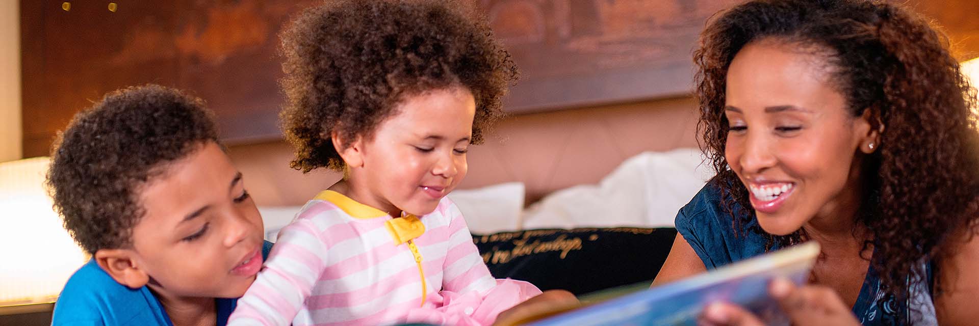 Mom reading to kids; AA; resort bed; brother; sister