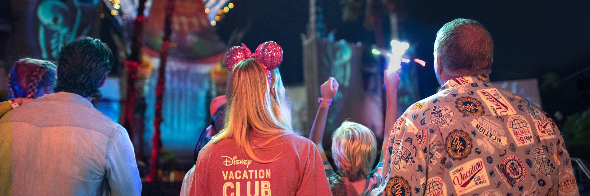 photo of fireworks over Disney World as viewed by a family from behind.