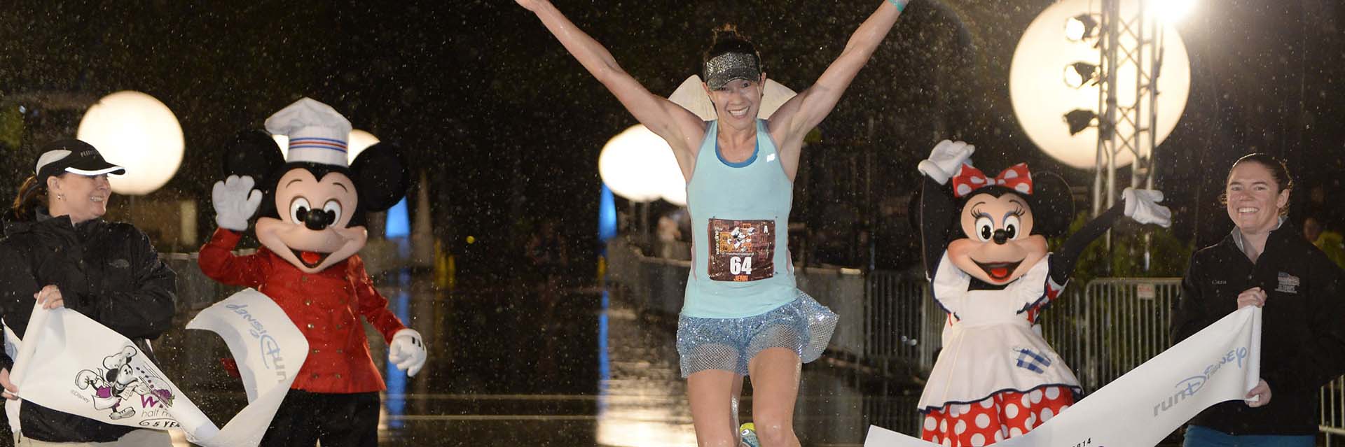 Food and Wine runner crossing finish line with Mickey and Minnie