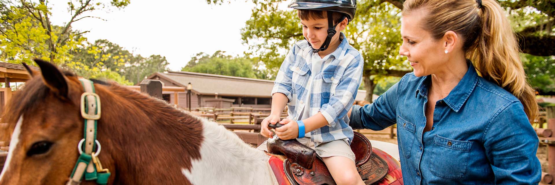Child riding horse at got wilderness campgrounds; son and mother